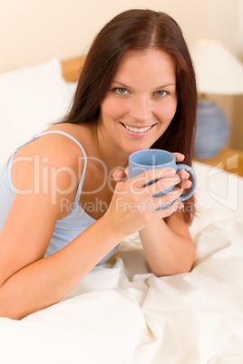 Bedroom - young woman drink coffee in bed