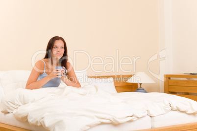 Bedroom - young woman drink coffee in bed