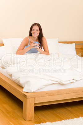 Bedroom - young woman drink coffee in bed