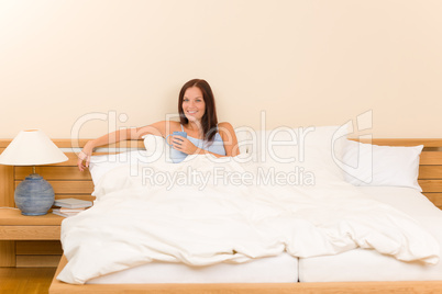 Bedroom - young woman drink coffee in bed