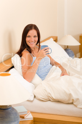 Bedroom - young woman drink coffee in bed