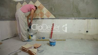 man installs ceramic tile