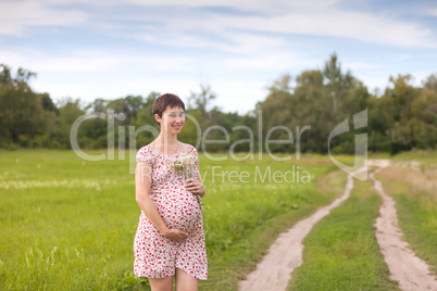 Pregnant woman with chamomile bouquet