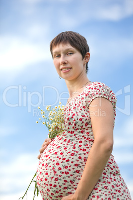 Pregnant woman with chamomile bouquet