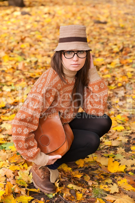 young girl with handbag on yellow leaf background