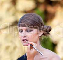 Makeup master applying lipstick