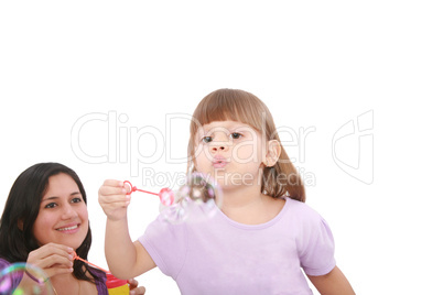 Portrait of funny lovely little girl blowing soap bubbles with h