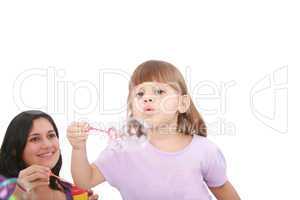 Portrait of funny lovely little girl blowing soap bubbles with h