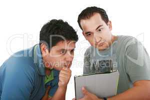 Two friends looking surprised at tablet computer against a white