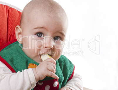 baby sitting and eating an apple