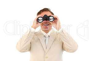 Smiling businessman looking through binoculars