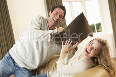 Young couple having fun laughing on sofa