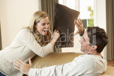 Young couple having fun laughing on sofa