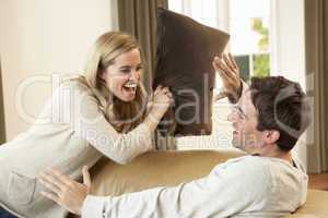 Young couple having fun laughing on sofa