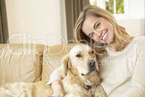 Young woman with dog sitting on sofa