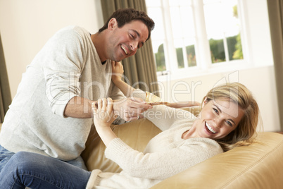 Young couple having fun laughing on sofa