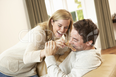 Young couple having fun laughing on sofa