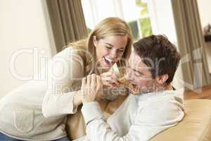 Young couple having fun laughing on sofa