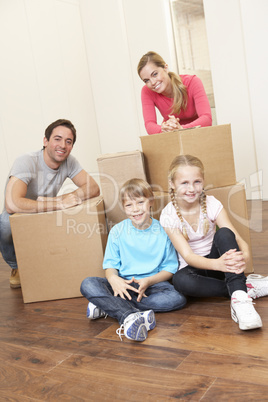 Young family on moving day looking happy among boxes