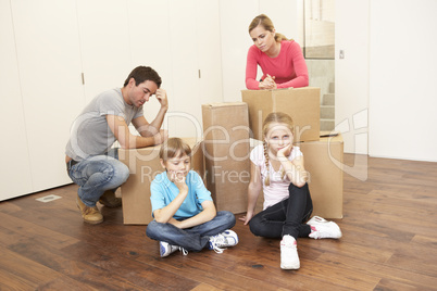 Young family looking upset among boxes