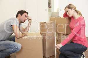 Young couple looking upset among boxes