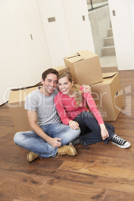 Young couple on moving day sitting with cardboard boxes