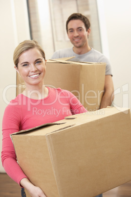 Young couple on moving day carrying cardboard boxes