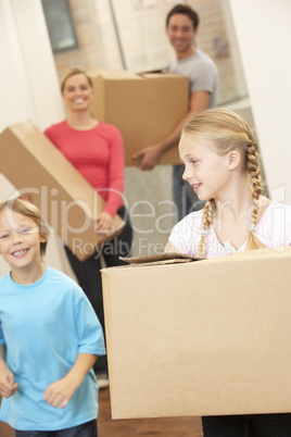 Family happy on moving day carrying cardboard boxes