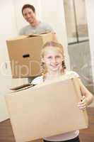 Girl with young man on moving day carrying cardboard box