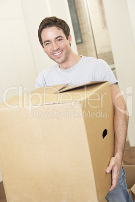 Young man on moving day holding and carrying cardboard box