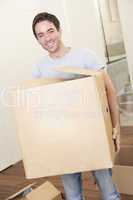 Young man on moving day holding and carrying cardboard box