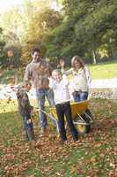 Family throwing autumn leaves into the air in garden