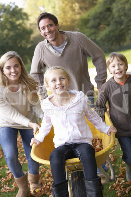 Family having fun with autumn leaves in garden