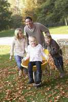 Family having fun with autumn leaves in garden