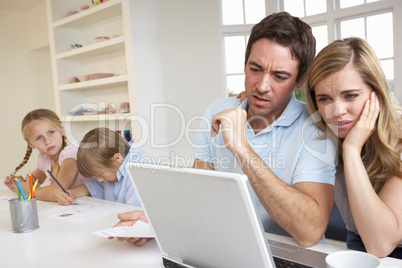 Young couple thinking and looking at a laptop computer