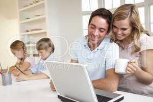 Happy young family looking and reading a laptop computer