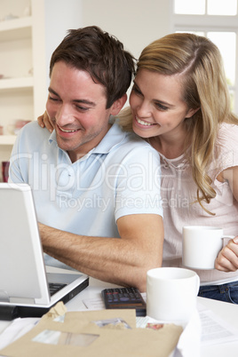 Happy young happy couple looking and reading a laptop computer