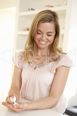 Young woman using hand sanitizer