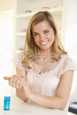 Young woman using hand sanitizer