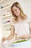 Young woman splitting pea in kitchen