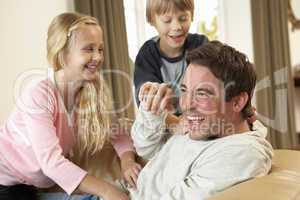 Young father with children having fun on sofa