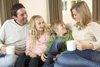 Happy young family sitting and talking on sofa