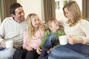 Happy young family sitting and talking on sofa