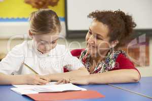 Schoolgirl Studying In Classroom With Teacher