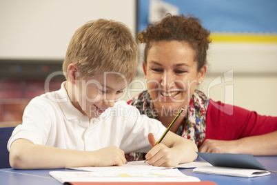 Schoolboy Studying In Classroom With Teacher