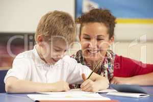 Schoolboy Studying In Classroom With Teacher