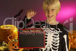 Halloween party with a boy child holding sign
