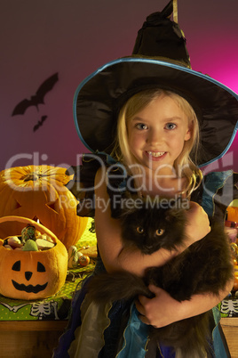 Halloween party with a child holding black cat in hand