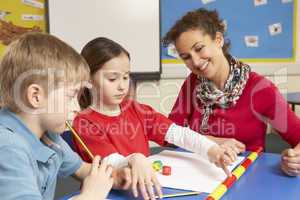 Schoolchildren Studying in classroom with teacher