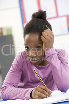 Stressed Schoolgirl Studying In Classroom